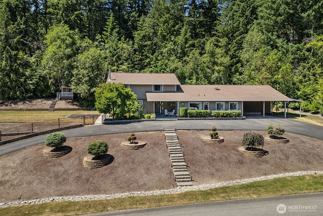 6830 SE Arlington Pl, Port Orchard, WA 98367 - view of front of property featuring driveway, an attached carport, and a forest view