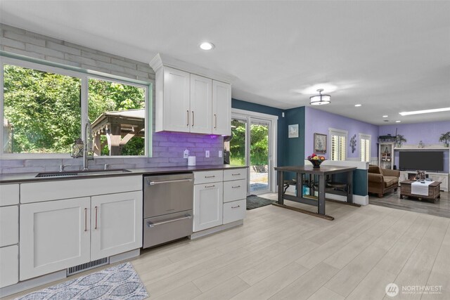 6830 SE Arlington Pl, Port Orchard, WA 98367 - kitchen with stainless steel dishwasher, light wood-style floors, white cabinets, dark countertops, and recessed lighting