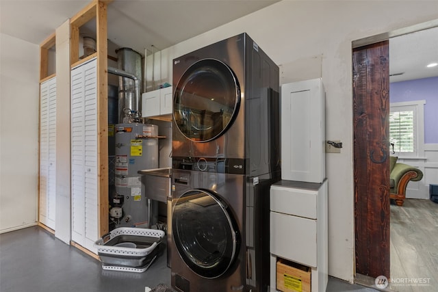 6830 SE Arlington Pl, Port Orchard, WA 98367 - washroom featuring water heater, stacked washer / dryer, and cabinet space