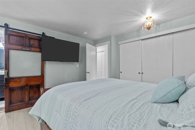 6830 SE Arlington Pl, Port Orchard, WA 98367 - bedroom featuring a closet, a barn door, and a textured ceiling