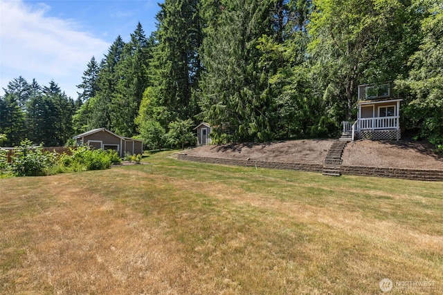 6830 SE Arlington Pl, Port Orchard, WA 98367 - view of green lawn with a storage unit and a view of trees