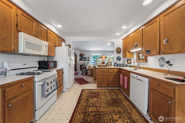 9923 74th Ave E, Puyallup, WA 98373 - kitchen featuring white appliances, brown cabinetry, light countertops, light floors, and recessed lighting