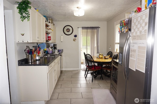 608 S 6th Ave, Kelso, WA 98626 - kitchen featuring stainless steel appliances, white cabinetry, a textured ceiling, dark countertops, and light tile patterned floors