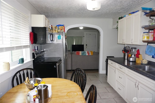 608 S 6th Ave, Kelso, WA 98626 - kitchen with appliances with stainless steel finishes, arched walkways, a textured ceiling, open shelves, and white cabinets