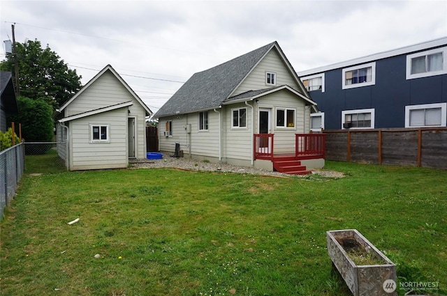 608 S 6th Ave, Kelso, WA 98626 - rear view of house with a fenced backyard, a deck, a shingled roof, and an outdoor structure