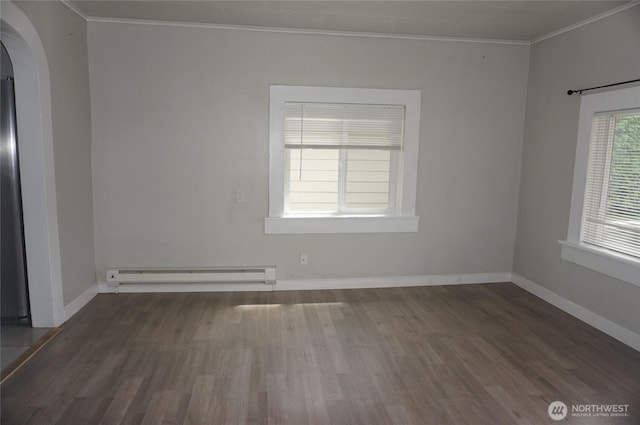 608 S 6th Ave, Kelso, WA 98626 - spare room featuring baseboard heating, crown molding, arched walkways, and wood finished floors