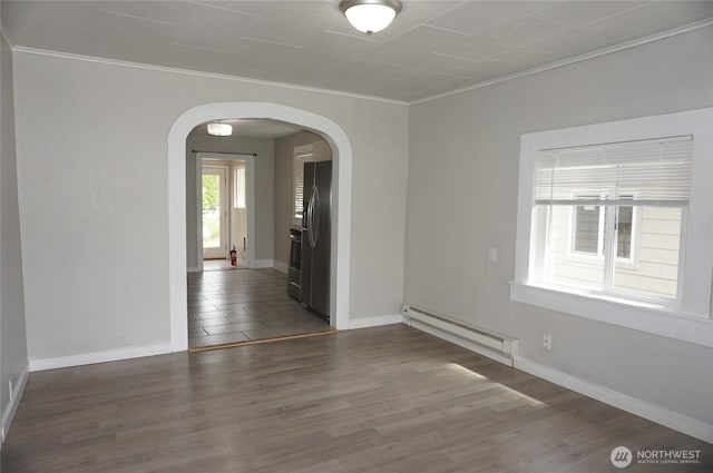 608 S 6th Ave, Kelso, WA 98626 - empty room featuring a baseboard radiator, arched walkways, ornamental molding, and wood finished floors