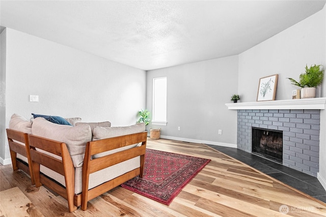 3104 Bill Mcdonald Pkwy Unit D104, Bellingham, WA 98225 - living room with wood finished floors, a brick fireplace, and a textured ceiling