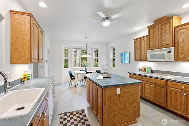 7506 Hawkstone Ave SW, Port Orchard, WA 98367 - kitchen with white appliances, light floors, ceiling fan, a center island, and dark countertops