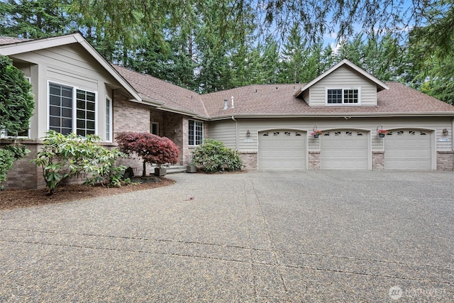 7506 Hawkstone Ave SW, Port Orchard, WA 98367 - view of front of home featuring an attached garage, brick siding, driveway, and a shingled roof