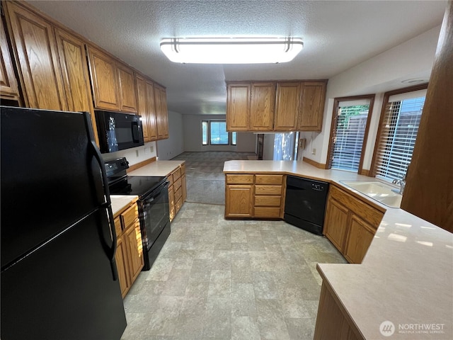 7908 53rd St W, University Place, WA 98467 - kitchen featuring black appliances, brown cabinetry, light countertops, a peninsula, and a textured ceiling