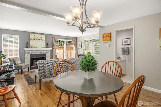 15600 116th Ave NE Unit E4, Bothell, WA 98011 - dining space with light wood-style flooring, a tile fireplace, and a chandelier