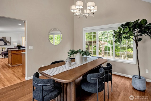 1125 Hemlock Ave SW, North Bend, WA 98045 - dining room with a chandelier, light wood-style flooring, and a towering ceiling