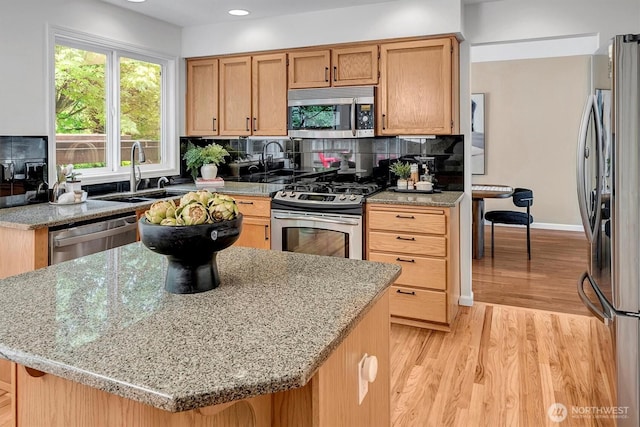 1125 Hemlock Ave SW, North Bend, WA 98045 - kitchen featuring stainless steel appliances, light wood-type flooring, decorative backsplash, light stone counters, and recessed lighting