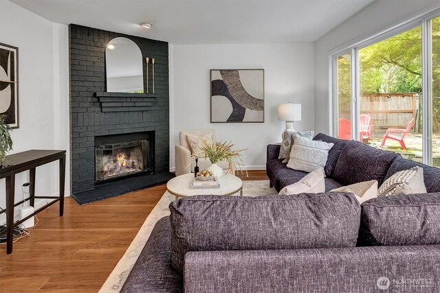 1125 Hemlock Ave SW, North Bend, WA 98045 - living area featuring wood finished floors and a brick fireplace
