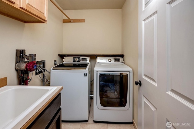 1125 Hemlock Ave SW, North Bend, WA 98045 - laundry area featuring cabinet space, washing machine and dryer, and light tile patterned floors
