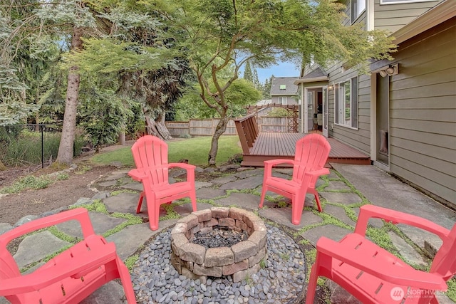 1125 Hemlock Ave SW, North Bend, WA 98045 - fenced backyard with an outdoor fire pit, a wooden deck, and a patio
