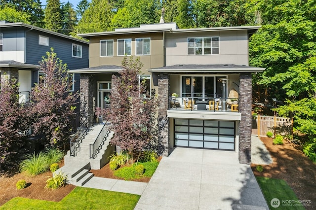7223 NE 118th Ct, Kirkland, WA 98034 - view of front of property with a garage, concrete driveway, stairway, a balcony, and stucco siding