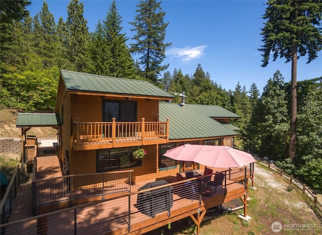 16537 Lakeview Dr, Leavenworth, WA 98826 - back of house with a metal roof, a view of trees, a wooden deck, and a standing seam roof