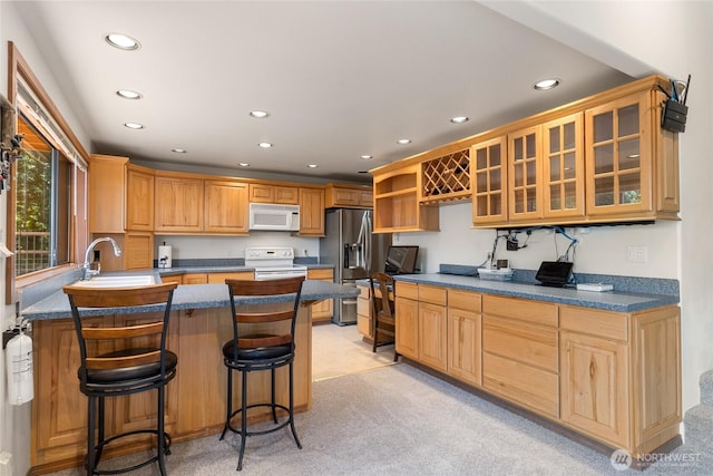 16537 Lakeview Dr, Leavenworth, WA 98826 - kitchen featuring white appliances, recessed lighting, a peninsula, glass insert cabinets, and light colored carpet
