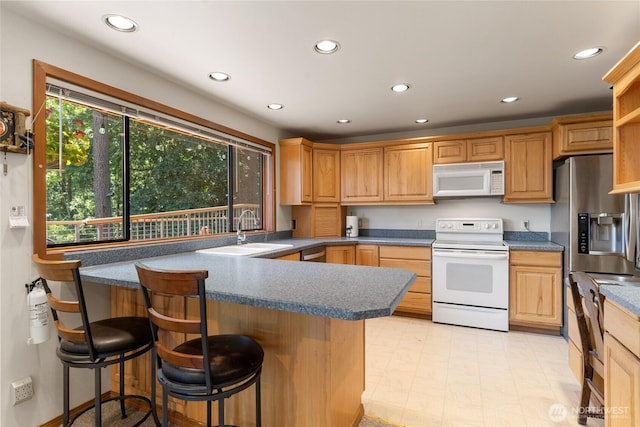 16537 Lakeview Dr, Leavenworth, WA 98826 - kitchen featuring stainless steel appliances, recessed lighting, a peninsula, a kitchen bar, and dark countertops