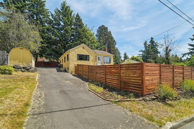 12260 5th Ave S, Seattle, WA 98168 - view of front of property featuring driveway, a shed, and stucco siding