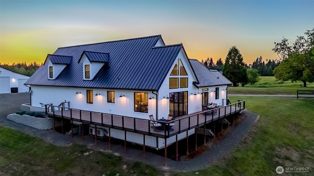 14045 Solberg Rd SE, Yelm, WA 98597 - back of property at dusk with a yard, a wooden deck, a standing seam roof, and a metal roof
