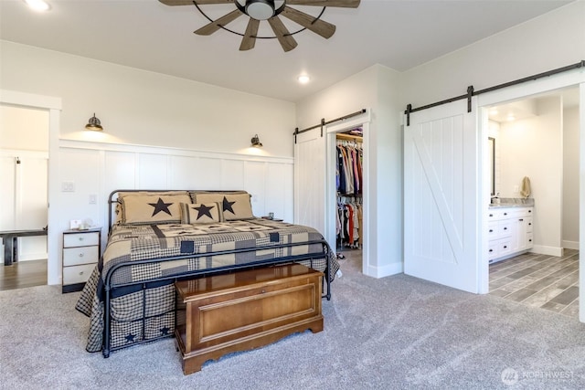 14045 Solberg Rd SE, Yelm, WA 98597 - carpeted bedroom with a barn door, a spacious closet, a closet, wainscoting, and connected bathroom