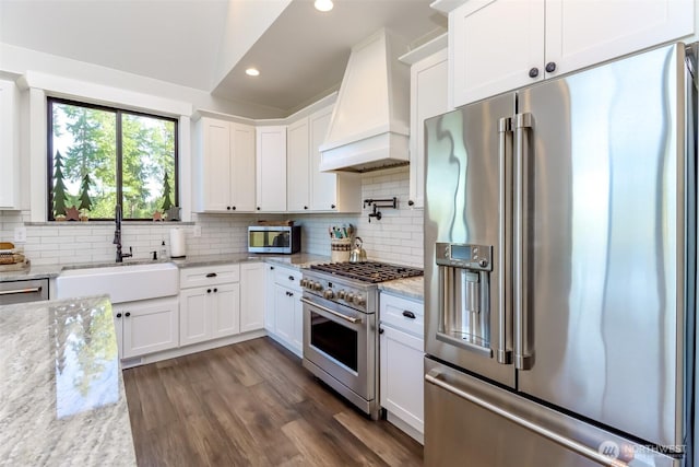 14045 Solberg Rd SE, Yelm, WA 98597 - kitchen featuring high quality appliances, premium range hood, white cabinets, recessed lighting, and tasteful backsplash