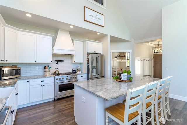 14045 Solberg Rd SE, Yelm, WA 98597 - kitchen with high quality appliances, custom exhaust hood, dark wood-style floors, backsplash, and white cabinets