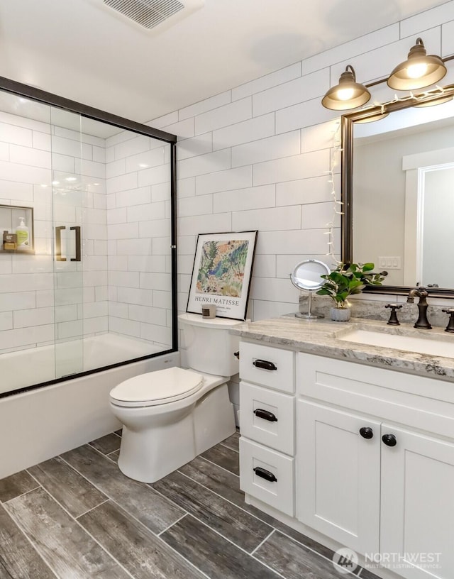 14045 Solberg Rd SE, Yelm, WA 98597 - full bathroom with vanity, bath / shower combo with glass door, wood tiled floors, and tile walls