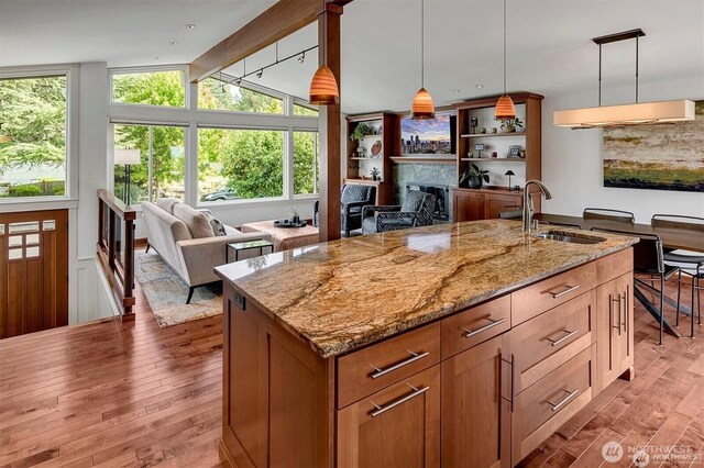 5829 112th Pl NE, Kirkland, WA 98033 - kitchen featuring a fireplace, light wood-style floors, open floor plan, and light stone countertops