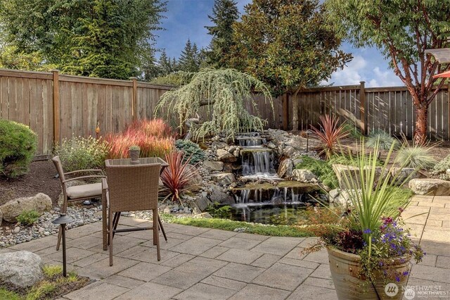 5829 112th Pl NE, Kirkland, WA 98033 - fenced backyard with a patio area, a small pond, and outdoor dining area