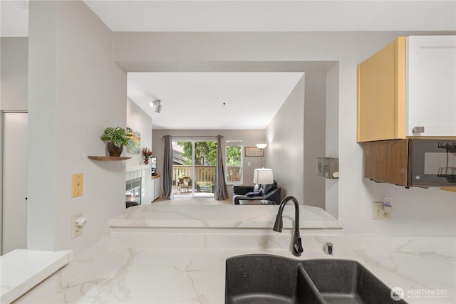 215 100th St SW Unit A305, Everett, WA 98204 - kitchen featuring marble look tiles, light stone countertops, and open floor plan