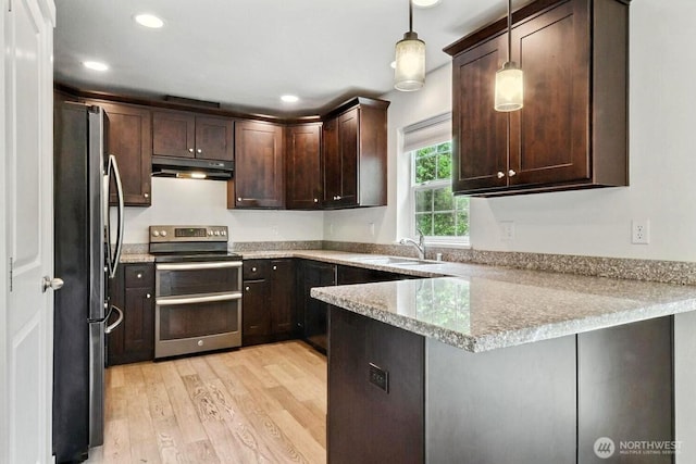 237 SW Oak Rd, Port Orchard, WA 98367 - kitchen with stainless steel appliances, under cabinet range hood, light wood-type flooring, dark brown cabinets, and a peninsula