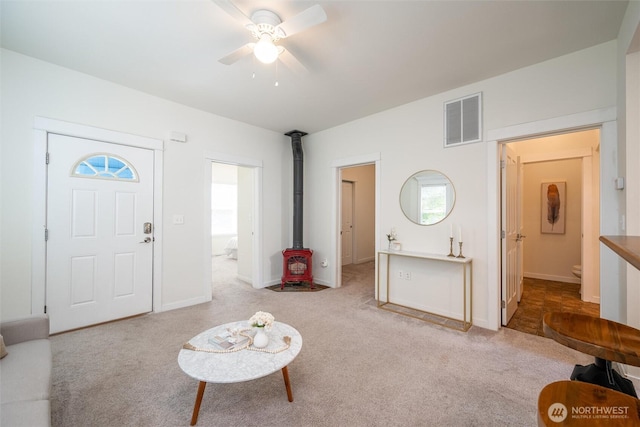 2226 King St, Bellingham, WA 98225 - carpeted living room with a wood stove, a ceiling fan, and healthy amount of natural light