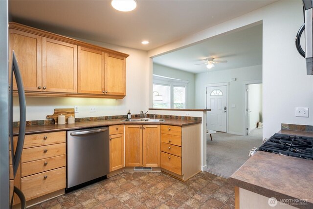 2226 King St, Bellingham, WA 98225 - kitchen with stainless steel appliances, a peninsula, dark countertops, a ceiling fan, and dark stone finish flooring