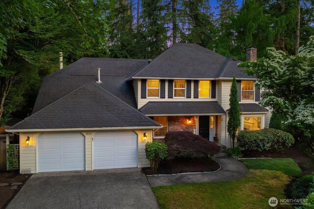 2892 160th Pl NE, Bellevue, WA 98008 - traditional home featuring driveway, a chimney, a garage, covered porch, and a shingled roof