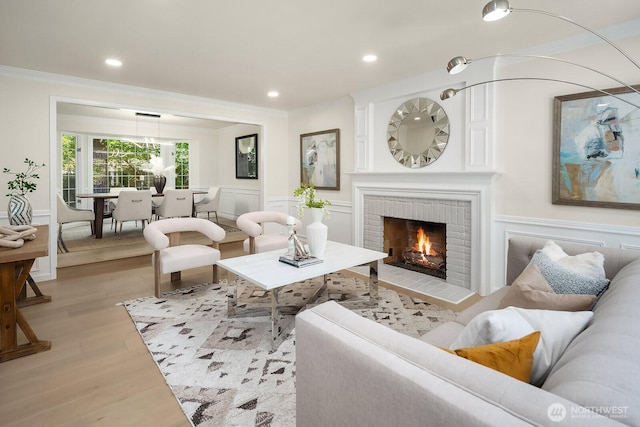 2892 160th Pl NE, Bellevue, WA 98008 - living room featuring light wood-style floors, a wainscoted wall, a decorative wall, ornamental molding, and a brick fireplace