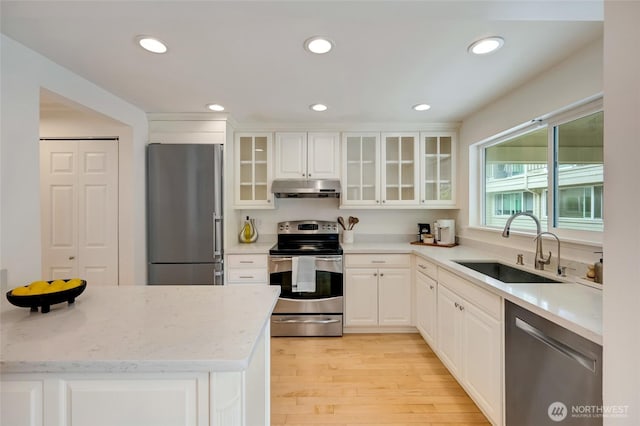 202 W Olympic Pl Unit 201, Seattle, WA 98119 - kitchen featuring stainless steel appliances, under cabinet range hood, recessed lighting, white cabinetry, and glass insert cabinets