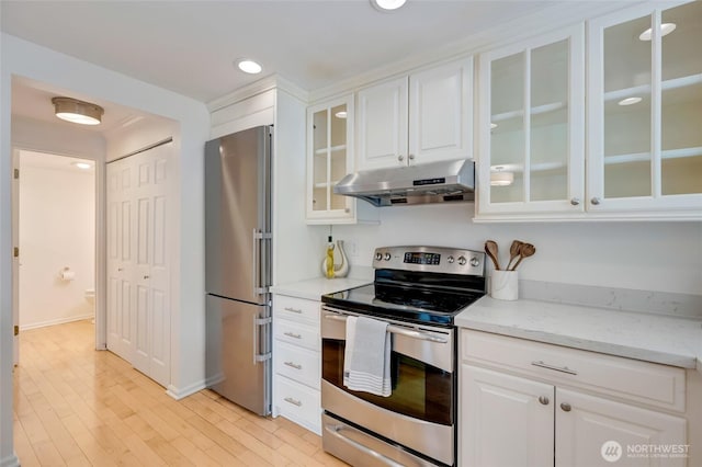202 W Olympic Pl Unit 201, Seattle, WA 98119 - kitchen with appliances with stainless steel finishes, under cabinet range hood, white cabinetry, light wood-style flooring, and recessed lighting