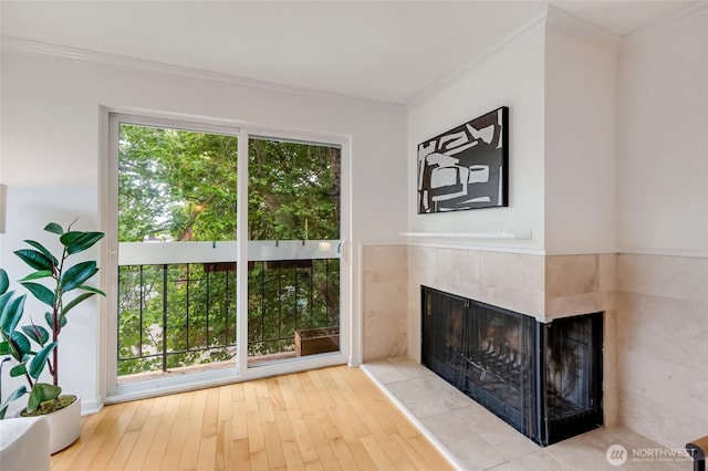 202 W Olympic Pl Unit 201, Seattle, WA 98119 - unfurnished living room with a tiled fireplace, hardwood / wood-style floors, and crown molding