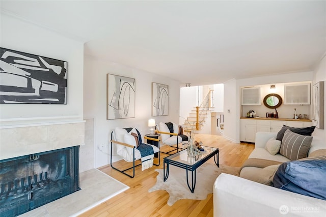 202 W Olympic Pl Unit 201, Seattle, WA 98119 - living room with light wood-type flooring, stairs, wet bar, and a tiled fireplace