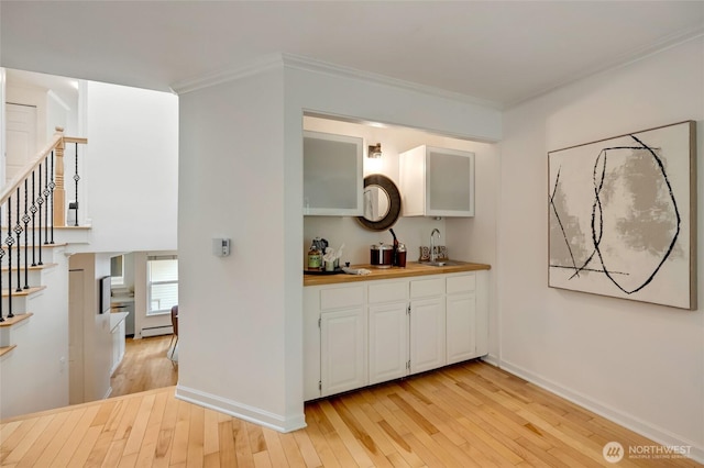 202 W Olympic Pl Unit 201, Seattle, WA 98119 - indoor wet bar featuring light wood-type flooring, stairs, ornamental molding, and a baseboard heating unit