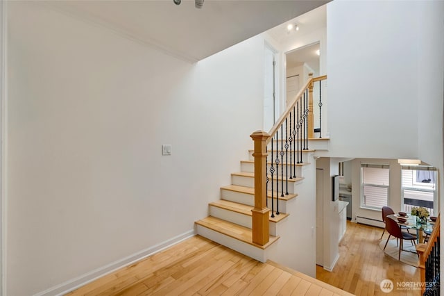 202 W Olympic Pl Unit 201, Seattle, WA 98119 - stairs featuring a baseboard heating unit and hardwood / wood-style flooring