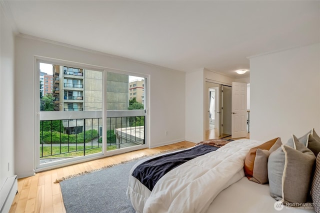 202 W Olympic Pl Unit 201, Seattle, WA 98119 - bedroom with baseboard heating, access to exterior, ornamental molding, and wood finished floors