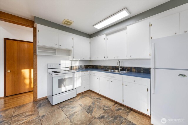2104 E Ave, Anacortes, WA 98221 - kitchen with white appliances, dark countertops, white cabinetry, and stone finish flooring