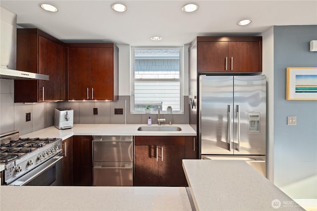 1115 24th Ave S, Seattle, WA 98144 - kitchen with appliances with stainless steel finishes, wall chimney range hood, light countertops, recessed lighting, and dark brown cabinets
