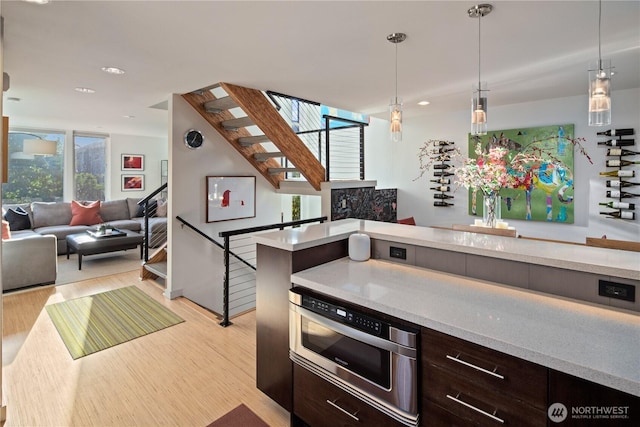 1115 24th Ave S, Seattle, WA 98144 - kitchen featuring open floor plan, dark brown cabinetry, light wood-style flooring, pendant lighting, and recessed lighting