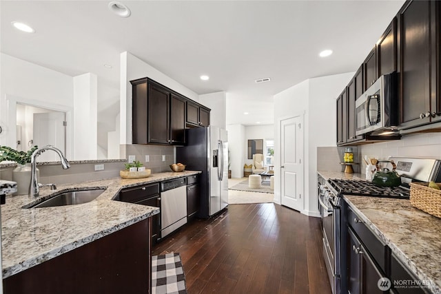 31 157th Ln SE, Bothell, WA 98012 - kitchen with stainless steel appliances, light stone countertops, backsplash, dark wood-style flooring, and dark brown cabinetry